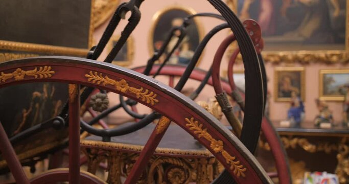Close up shot of a horse drawn carriage, showing wheels spokes, hub and suspension. Horse drawn carriage wheels inside museum.