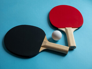 Pingpong rackets and ball isolated on light blue background. Equipment for playing table tennis.