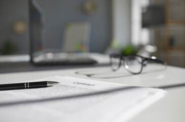 Closeup focus of paper contract and pen for signature laying on office desk. Close up of paperwork...