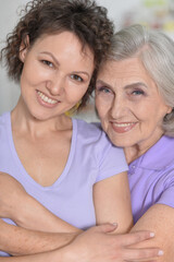 Mature woman embracing with adult daughter at home