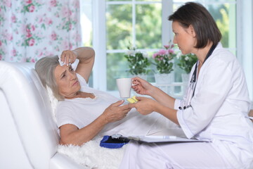 Sick senior woman portrait in hospital with g doctor
