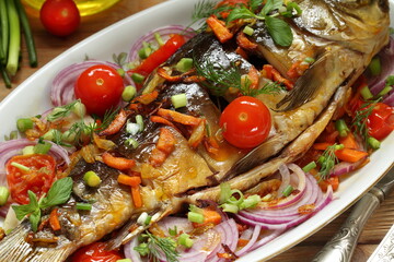 Fried carp with vegetables on a white background