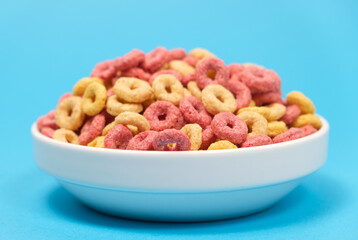 Quick cereal breakfast in the form of rings on a plate on a blue background