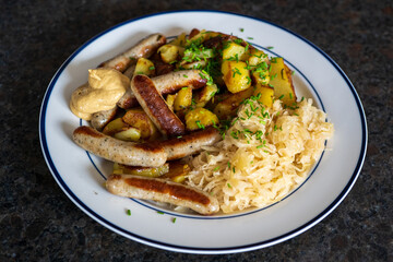 ready to eat, bratwurst and sauerkraut with fried potatoes and sauce