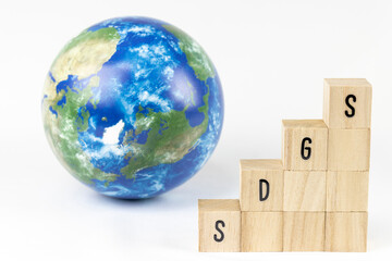 木のブロックのSDGsと、地球儀。SDGsのイメージ