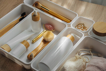 Cosmetics products arranged in white organizers. Creative Drawer Organizing. Storage beauty products and accessories.