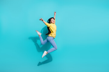 Full length photo of sweet adorable woman wear yellow pullover jumping high empty space isolated teal color background