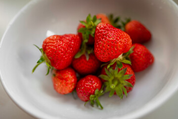Ripen fresh red strawberry fruits in the white bowl, close-up from the diagonal top