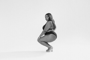 Full photo of superb plus size girl posing in studio on the gray background. Copy space. Concept of body acceptance, body positivity. Love yourself.