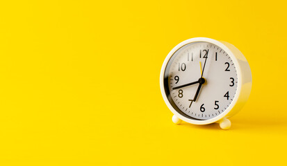 white alarm clock on a yellow background time concept with keywords working time