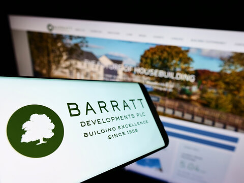 Stuttgart, Germany - 05-29-2022: Mobile phone with logo of property company Barratt Developments plc on screen in front of business website. Focus on center-left of phone display.