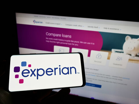Stuttgart, Germany - 05-29-2022: Person holding smartphone with logo of credit reporting company Experian plc on screen in front of website. Focus on phone display.