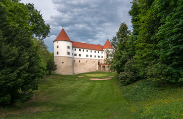 Fototapeta na wymiar Castle Mokrice on a spring evening with dramatic clouds and forest. A fortress in the woods.
