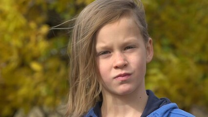 Closeup portrait of a serious adorable little girl. Slow motion