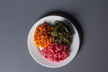 Colorful noodles on a white plate