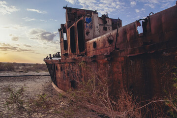 Plakat Cemetery of old ships on the former bank of Aral sea during sunrise, Muynak, Uzbekistan