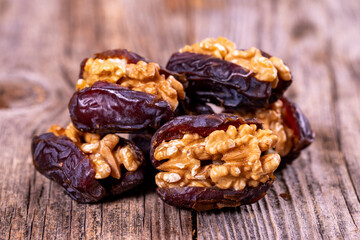 Walnut-stuffed dates on a wood floor. Close-up. Arabian luxury for special occasions such as Ramadan and Eid holidays. local name cevizli hurma