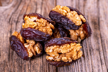Walnut-stuffed dates on a wood floor. Close-up. Arabian luxury for special occasions such as Ramadan and Eid holidays. local name cevizli hurma