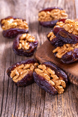 Walnut-stuffed dates on a wood floor. Close-up. Arabian luxury for special occasions such as Ramadan and Eid holidays. local name cevizli hurma