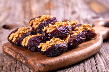 Walnut-stuffed dates on a wood floor. Close-up. Arabian luxury for special occasions such as Ramadan and Eid holidays. local name cevizli hurma