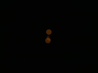 mysterious small, luminous orange circles on a black background © TK_Office