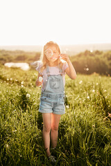 Caucasian girl playing with bubbles on the meadow