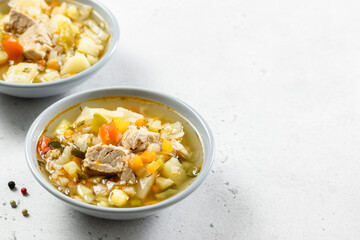 Homemade pork soup with vegetables in plates. Top view, copy space, flat lay.