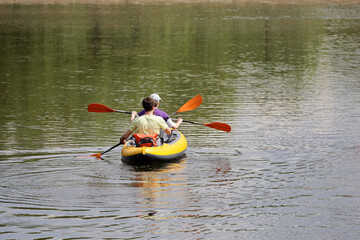 Couple on rowing boat, guy and girl boating on a lake. Summer leisure, water sports