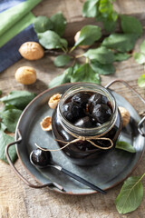 Handmade jam made from green fresh walnuts on a wooden background. Organic walnut jam, healthy food.