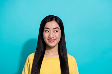 Fototapeta premium Photo of pretty dreamy woman wear yellow pullover smiling looking empty space isolated teal color background