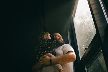 Daddy and daughter looking through window