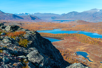Epic view of vast arctic landscape of Stora Sjofallet National Park, Sweden, on autumn day. Mountains and valleys of Lapland. Autumn colors in the Arctic. Valley of Bietsavrre and Risjakjavrre lakes.
