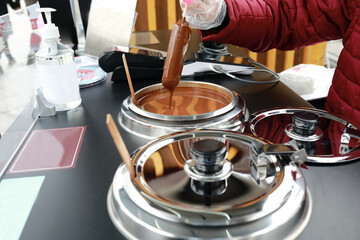 Seller dipping ice cream in chocolate