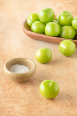ripe green plum fruits served with salt on table