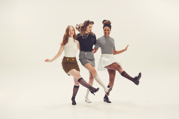 Pretty young girls in retro 80s, 90s fashion style, outfits isolated over white studio background....