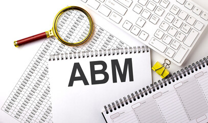 ABM text written on a notebook on chart with keyboard and planning