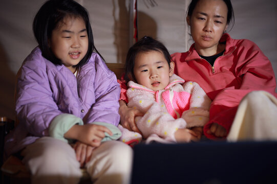 Family Watching Tv In Tent