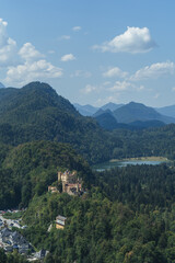 Fototapeta na wymiar Castle in the mountains, Bavaria Alps with castle, Beautiful view in Alps in summer, Neuschwanstein castle view, View from above to the castle, View in Bavaria Alps from the top, Mountains and Castle
