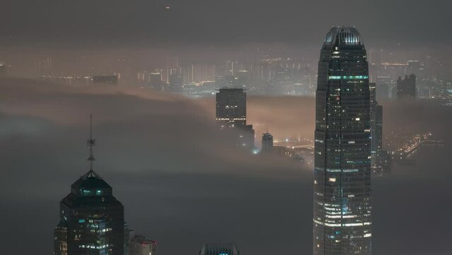 Timelapse Drone shot of the Hong Kong International Finance Centre IFC with clouds passing by the buildings at sunset. Gotham scene.