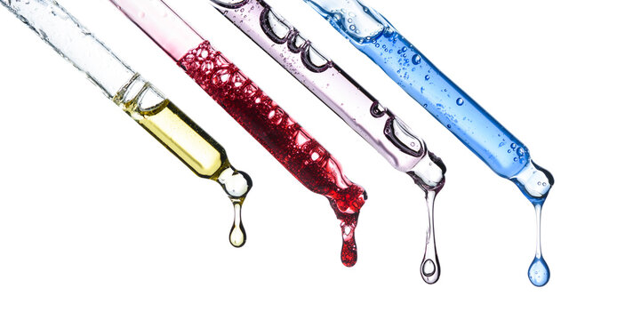 Glass cosmetic pipette droppers with different colored skincare serum and oil, with hanging liquid drop, isolated on white background