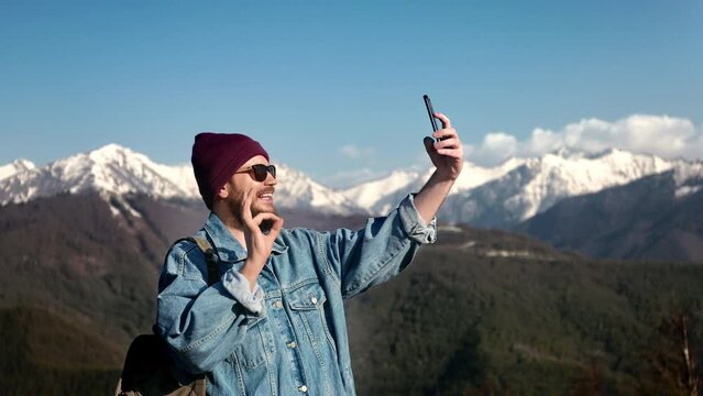 Handsome bearded traveller backpacker man taking selfie picture photo using mobile smartphone 