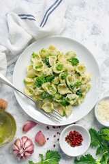Italian pasta - orecchiette with turnip greens on light background. Mediterranean diet. Top view.