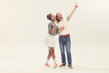 Delighted young man and woman in vintage retro style outfits running isolated on white background....