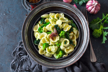 Italian pasta Orecchiette with brocoli and anchovies on dark table. Top view with copy space....