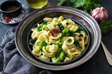 Italian pasta Orecchiette with brocoli and anchovies on dark table. Top view with copy space. Healthy food.