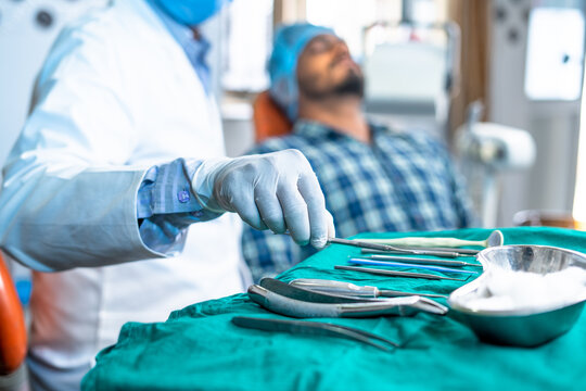 Close up shot of dentist using medical equipment for teeth or oral treatment at hospital - concept of expertise, professional occupation and dental care.