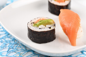 Sushi and rolls on a blue plate.