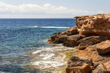 Fototapeta na wymiar Krast cape cliffs stretching into the blue mediterranean sea in Ibiza, Balearic Islands, Spain