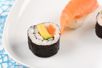 Sushi and rolls on a blue plate.