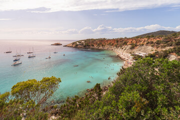 Beautiful view of Ibiza island beach Cola d'Hort in the rays of the setting sun. Balearic Islands, Spain